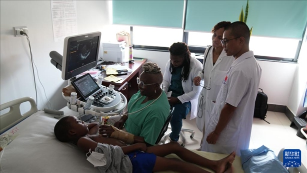 3月4日，在多米尼克羅索的中多友誼醫(yī)院，援多醫(yī)療隊(duì)成員、南方醫(yī)科大學(xué)第五附屬醫(yī)院心血管內(nèi)科主治醫(yī)師駱志鵬與當(dāng)?shù)蒯t(yī)生共同診療。新華社記者 王朝 攝
