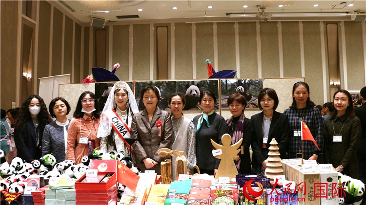 中國(guó)駐日本大使吳江浩夫人丁玥（左五）與使館人員在展位前合影留念。人民網(wǎng) 許可攝