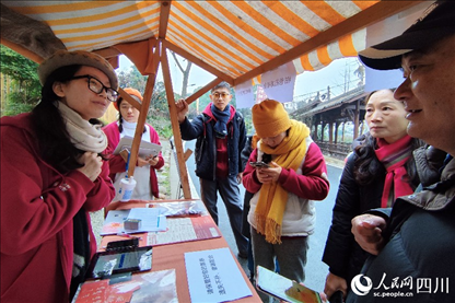 1月6日，“2024成都蒲江柑甜采摘節(jié)”上，記者見到了小萌（左一）和許多年輕人忙著做訪客接待、現(xiàn)場布置、票務(wù)核對、采摘服務(wù)等工作。人民網(wǎng)記者朱虹攝