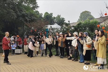 葉科（左一）給前來參與活動(dòng)的“柑爸柑媽”介紹生態(tài)種植果。人民網(wǎng)記者朱虹攝