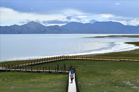 △ 游客行走在青海瑪多縣冬格措納湖畔的木棧道上。