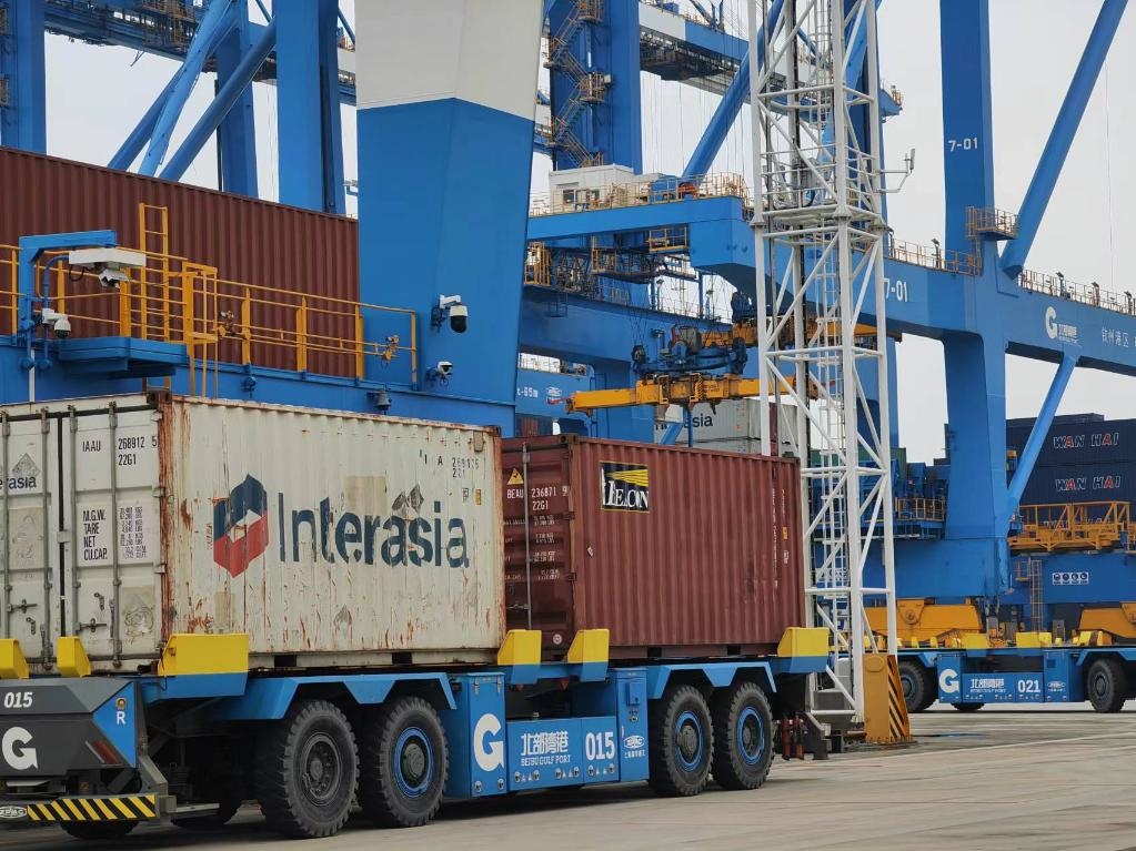 在欽州自動(dòng)化集裝箱碼頭，智能導(dǎo)引運(yùn)輸車在運(yùn)送集裝箱。新華社記者趙歡 攝