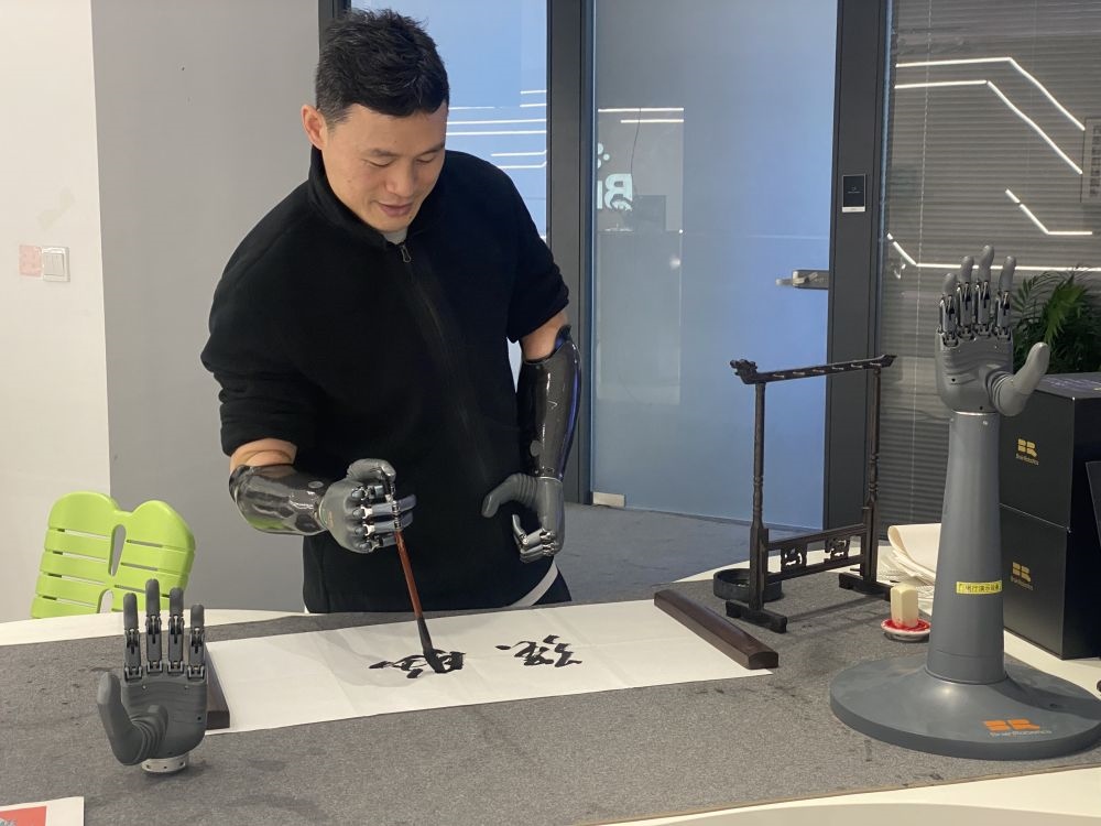 2024年3月29日，在浙江強(qiáng)腦科技有限公司展廳內(nèi)，失去雙手的產(chǎn)品體驗(yàn)官倪敏成依靠智能仿生手寫毛筆字。新華社記者 魏一駿 攝