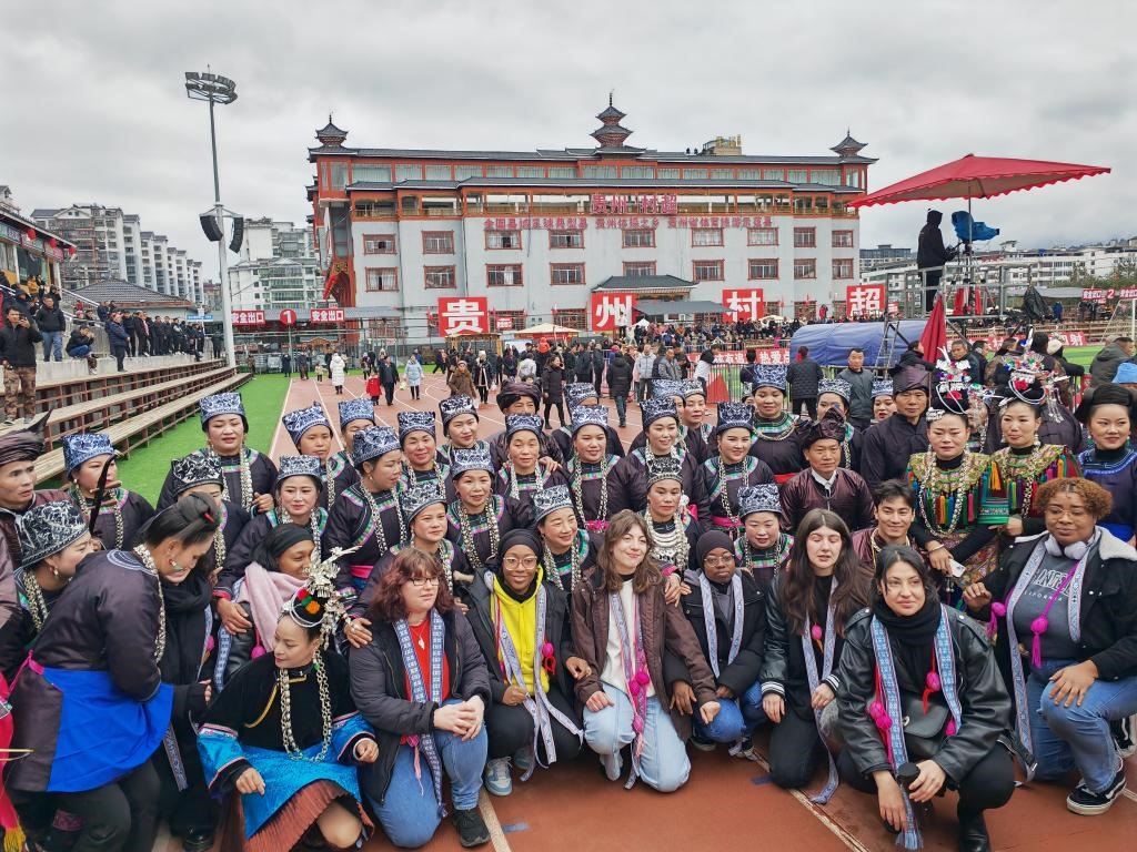 法國青年在“村超”賽場邊與參加表演的村民合影。新華社記者 羅羽 攝