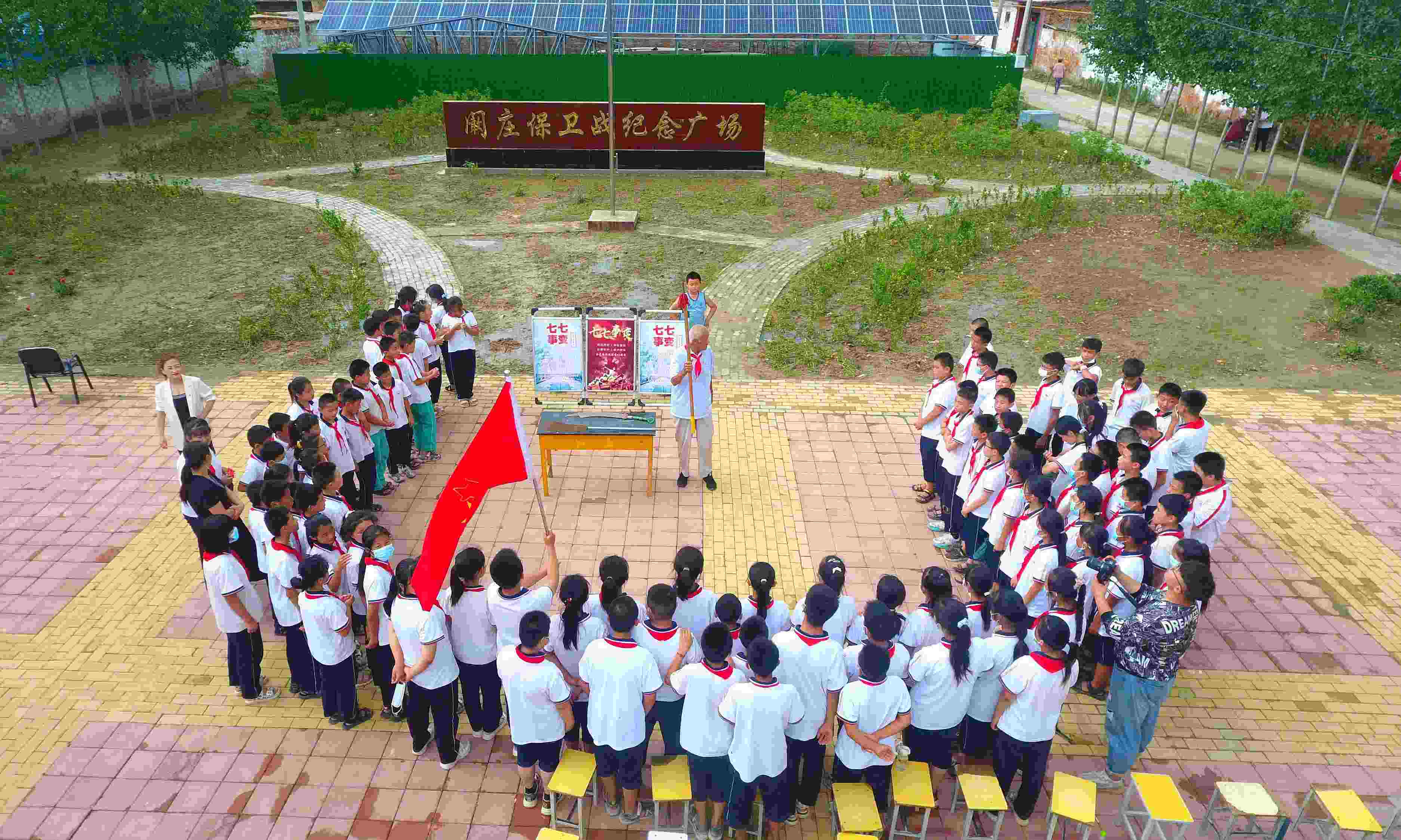 2022年7月6日，山東省聊城市，在茌平區(qū)菜屯鎮(zhèn)闞莊村的闞莊保衛(wèi)戰(zhàn)紀(jì)念廣場，闞莊保衛(wèi)戰(zhàn)親歷者王光木老人為小學(xué)生們講述抗戰(zhàn)故事，展示大刀、長矛。