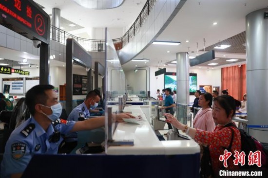 圖為旅客在磨憨口岸辦理通關(guān)手續(xù)。雷雨 攝