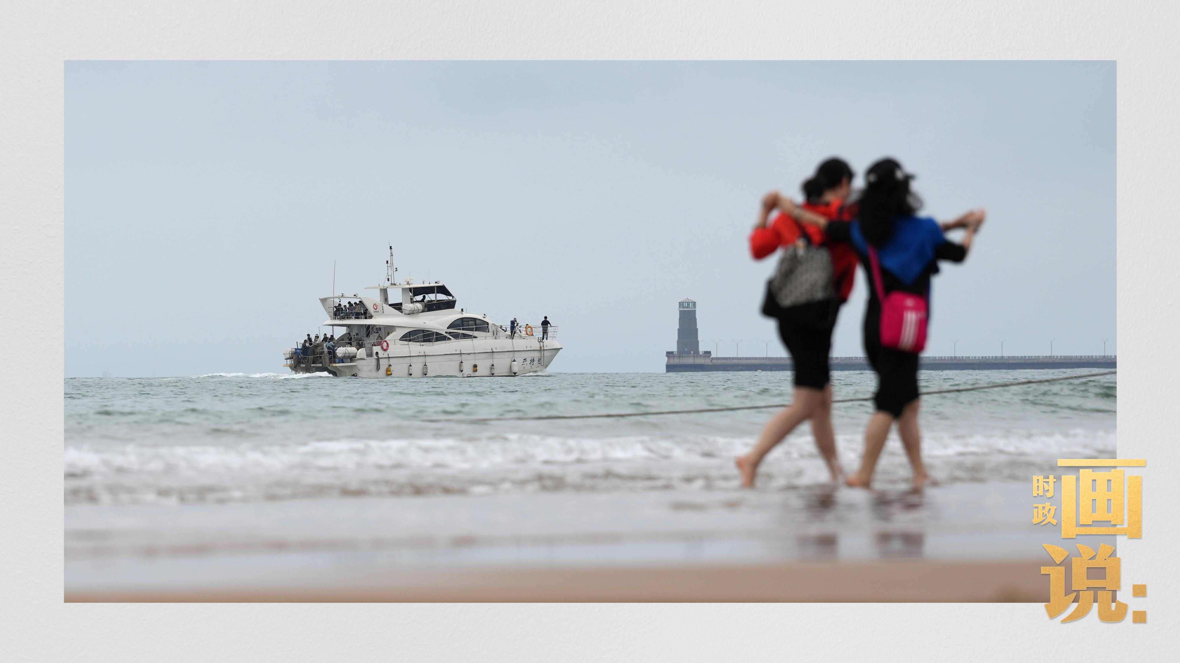 △日照陽(yáng)光海岸綠道上的萬(wàn)平口景區(qū)，一對(duì)游客在海浪中翩然起舞。