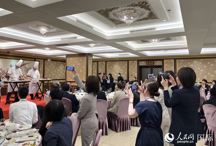 國(guó)家級(jí)非物質(zhì)文化遺產(chǎn)、全聚德片鴨工藝吸引代表團(tuán)成員拍照留念。