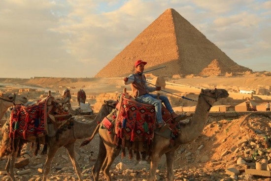 1月24日，商販騎駱駝離開埃及吉薩金字塔景區(qū)。新華社記者 隋先凱 攝