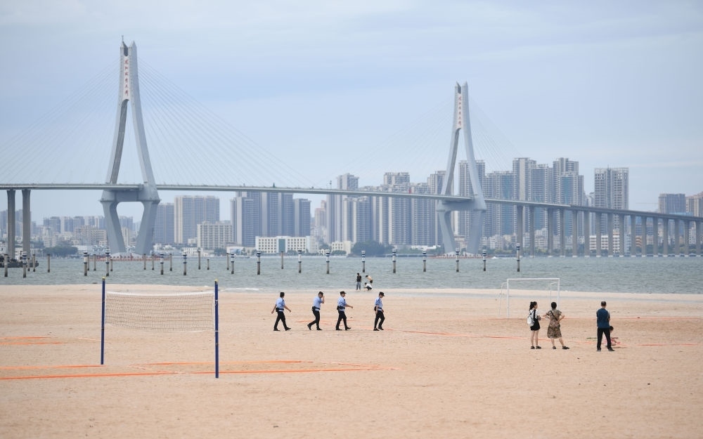2023年7月17日，廣東湛江五環(huán)廣場(chǎng)的沙灘上，公安民警在執(zhí)勤巡邏。新華社記者 鄧華 攝