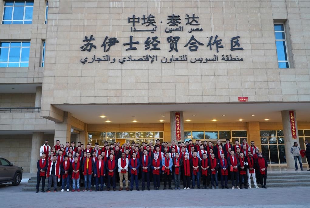 2024年2月11日，在位于埃及蘇伊士省的中?！ぬ┻_蘇伊士經(jīng)貿(mào)合作區(qū)，中埃員工在合作區(qū)辦公大樓前合影拜年。新華社發(fā)（泰達合作區(qū)供圖）