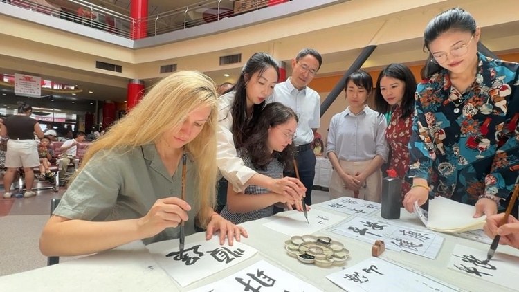 羅馬尼亞友人在活動(dòng)現(xiàn)場(chǎng)學(xué)寫(xiě)漢字。中國(guó)駐羅馬尼亞大使館領(lǐng)僑處供圖