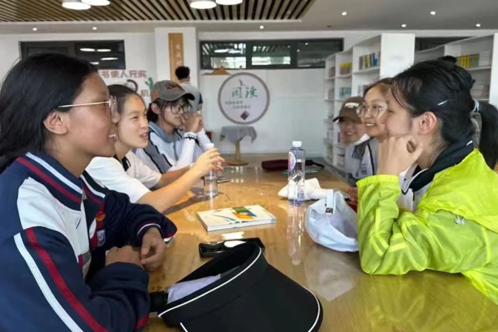 2023年7月10日，在果洛西寧民族中學，上海市大同中學學生（右）與果洛西寧民族中學學生交流。新華社發(fā)（果洛州教育局供圖）