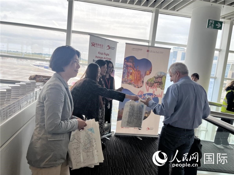 圖為工作人員向乘客發(fā)放復(fù)航首班禮物。 牛瑞飛攝