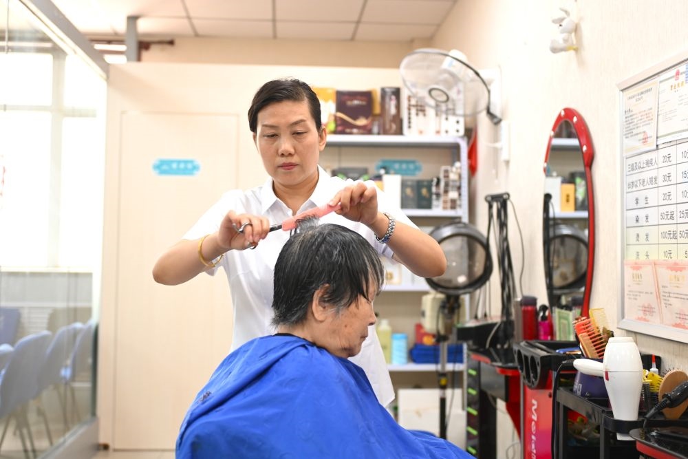 6月20日，長(zhǎng)城花園社區(qū)的志愿者為居民理發(fā)。