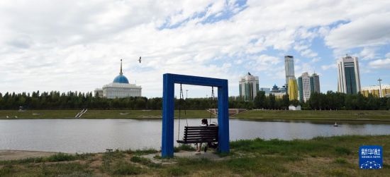 6月30日，一名女子在哈薩克斯坦首都阿斯塔納伊希姆河畔休息。新華社記者 王建華 攝