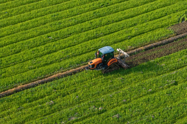 2024年3月19日，在湖南省常德市鼎城區(qū)謝家鋪鎮(zhèn)港中坪村，村民駕駛農(nóng)機(jī)翻耕田地（無(wú)人機(jī)照片）。新華社記者 陳思汗 攝