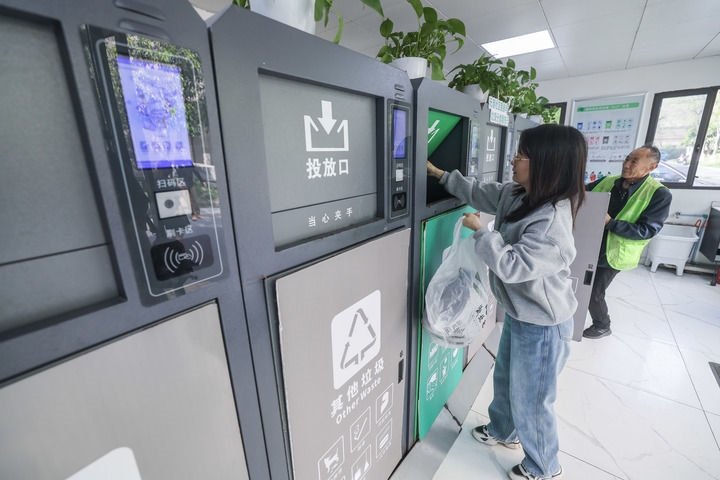 2024年4月10日，在浙江省湖州市吳興區(qū)飛英街道新華府小區(qū)內(nèi)，居民在垃圾分類(lèi)智能系統(tǒng)的指導(dǎo)下進(jìn)行垃圾分類(lèi)投放，居民的投放情況將實(shí)時(shí)匯總到智慧服務(wù)平臺(tái)，會(huì)有相應(yīng)的積分獎(jiǎng)勵(lì)。新華社記者 徐昱 攝