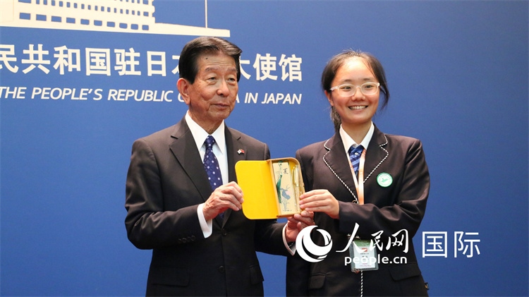 中國(guó)小大使向日本永旺1%俱樂部理事長(zhǎng)森美樹贈(zèng)送當(dāng)?shù)靥厣Y品。人民網(wǎng) 許可攝