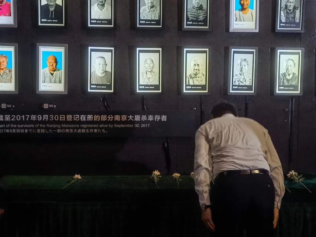 7月18日，人們向離世的南京大屠殺幸存者獻花、鞠躬。新華社記者邱冰清 攝