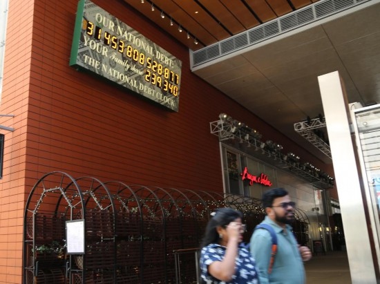 2023年5月29日，人們經(jīng)過(guò)美國(guó)紐約曼哈頓的“國(guó)債鐘”?！皣?guó)債鐘”是一個(gè)大型計(jì)數(shù)器，它實(shí)時(shí)更新美國(guó)的公共債務(wù)總額，并顯示出每個(gè)美國(guó)家庭所要負(fù)擔(dān)的數(shù)額。 新華社記者劉亞南攝