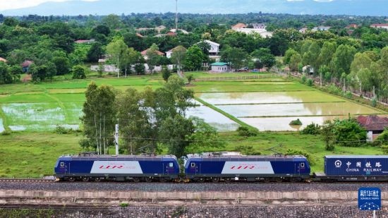 8月5日，由老撾籍火車司機(jī)獨(dú)立駕駛的滿載貨物的列車駛出萬象站，向中國昆明進(jìn)發(fā)（無人機(jī)照片）。新華社發(fā)（楊永全 攝）