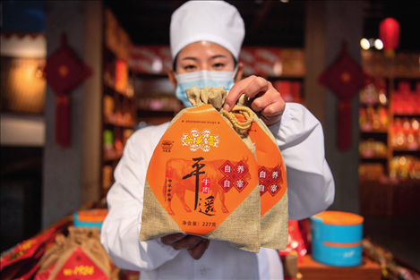 在位于山西省晉中市平遙縣的平遙古城南大街的一家平遙牛肉店內(nèi)，工作人員展示一款牛肉產(chǎn)品（資料照片）楊晨光攝 / 本刊