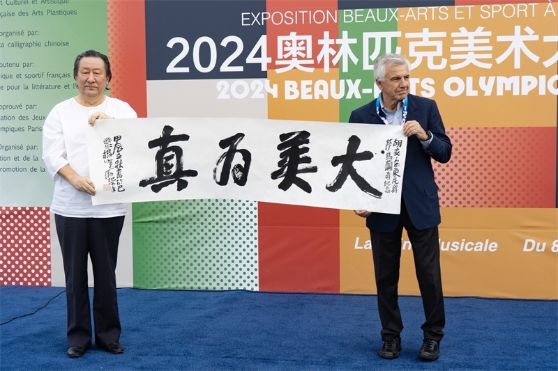 圖2：楊曉陽(yáng)向薩馬蘭奇贈(zèng)送書法（圖片：2024奧美組委會(huì)）