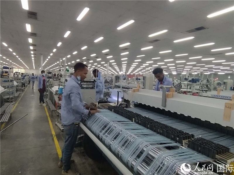 無錫金茂埃塞面料廠車間內(nèi)，當(dāng)?shù)毓と苏谝唤z不茍地作業(yè)。人民網(wǎng)記者 黃培昭攝
