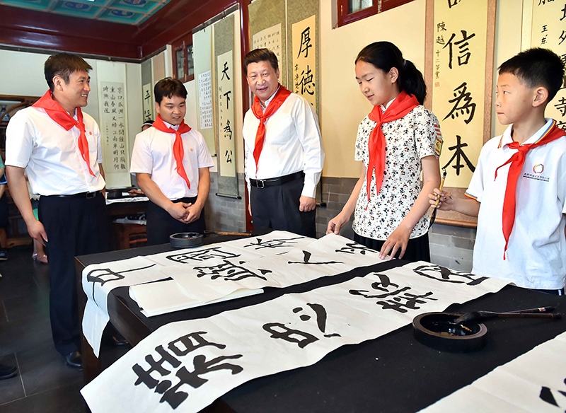2014年5月30日，習(xí)近平總書記來到北京市海淀區(qū)民族小學(xué)，參加慶?！傲弧眹H兒童節(jié)活動。這是總書記觀看學(xué)生書寫的毛筆字。