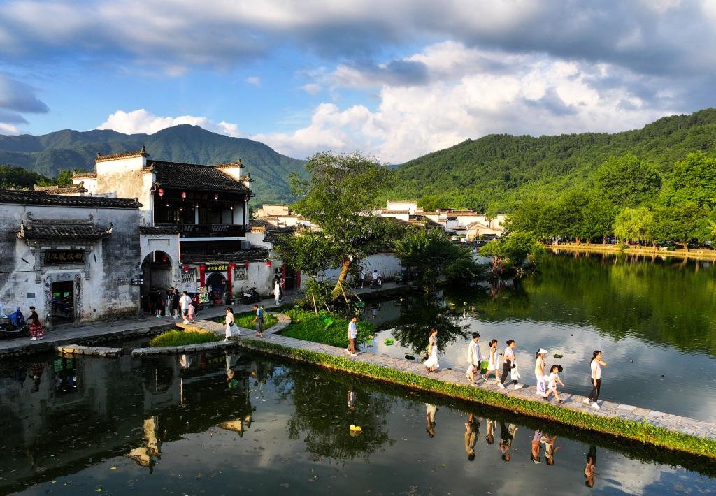 2024年7月7日，游客在安徽省黃山市黟縣宏村游玩。新華社記者杜宇攝