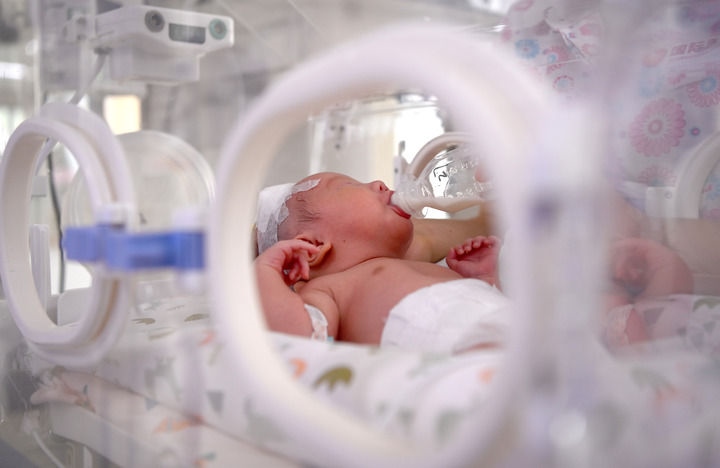 2024年6月1日，在西安國際醫(yī)學(xué)中心醫(yī)院新生兒科病房，護(hù)士為新生兒喂奶。 新華社記者 劉瀟 攝