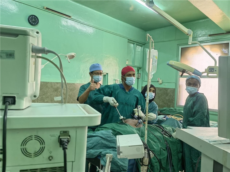 隊(duì)長蔣國慶（左一）關(guān)注當(dāng)?shù)蒯t(yī)生手術(shù)情況。中國援桑醫(yī)療隊(duì)供圖