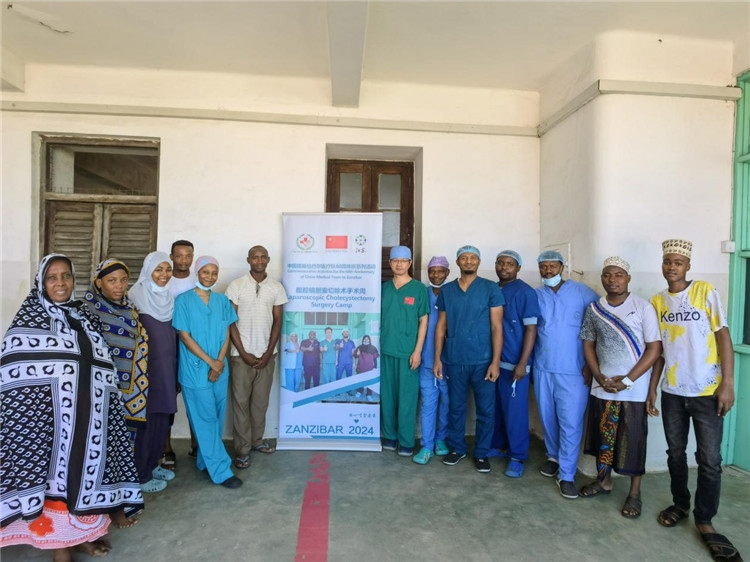 隊(duì)長蔣國慶（右七）和手術(shù)醫(yī)生、部分患者合影。中國援桑醫(yī)療隊(duì)供圖