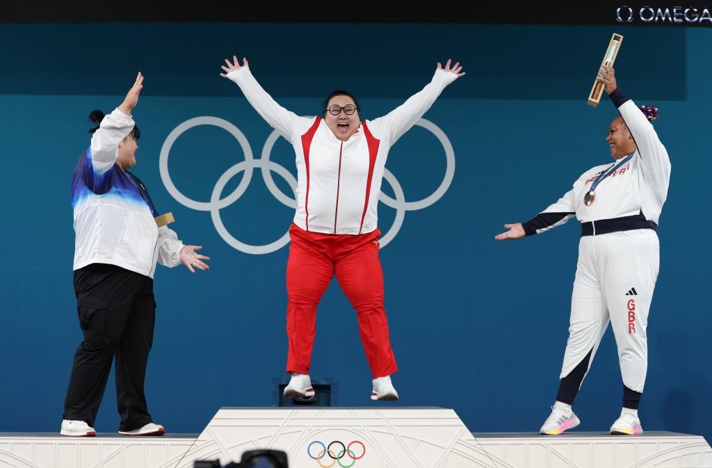 中國(guó)選手李雯雯（中）在巴黎奧運(yùn)會(huì)舉重女子81公斤以上級(jí)頒獎(jiǎng)儀式中登上領(lǐng)獎(jiǎng)臺(tái)（2024年8月11日攝）。新華社記者 楊磊 攝