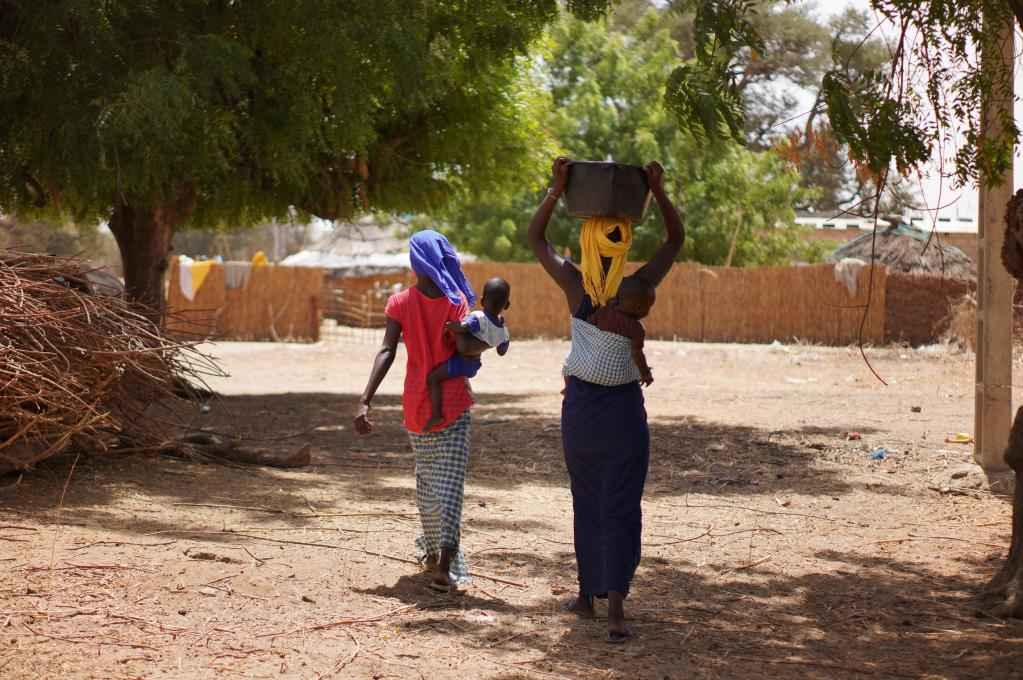 2023年3月20日，在塞內(nèi)加爾久爾貝勒區(qū)的泰內(nèi)富勒村，村民將取到的水運(yùn)回家。新華社記者 王子正 攝