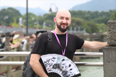 俄羅斯塔斯社執(zhí)行編輯葉夫根尼·扎多羅日內(nèi)在都江堰魚嘴拍照留念。（李佩藺 攝）