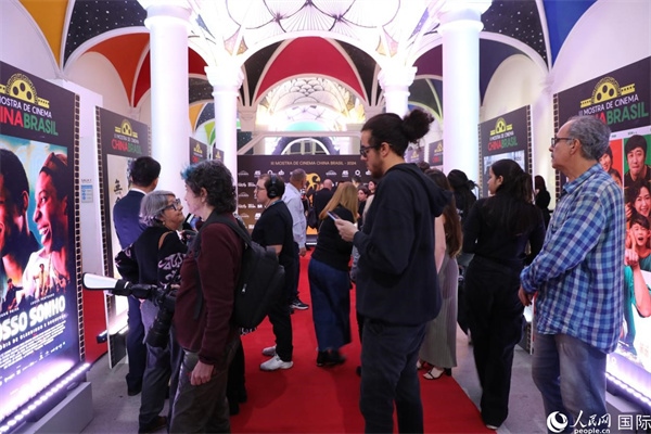 為期4天的第三屆中國－巴西電影展期間，來自中巴兩國的14部參展影片受到巴西電影愛好者和社會各界人士好評，圖為當?shù)赜^眾在影展舉辦地巴西里約熱內(nèi)盧勞拉—阿爾維姆文化之家的迎賓廳欣賞參展電影海報。 人民網(wǎng)記者 陳一鳴攝