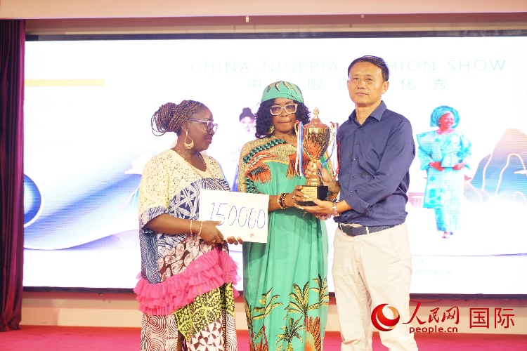 中國(guó)駐尼日利亞使館文化參贊兼中國(guó)文化中心主任李旭大（右）為最佳表現(xiàn)獎(jiǎng)?lì)C獎(jiǎng)（中）。人民網(wǎng)記者 姜宣攝