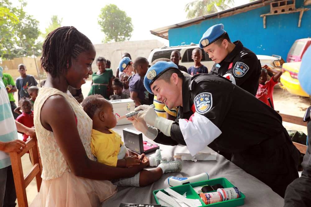 2017年12月28日，在利比里亞蒙羅維亞，中國(guó)維和警察防暴隊(duì)醫(yī)療人員為兒童做口腔檢查。