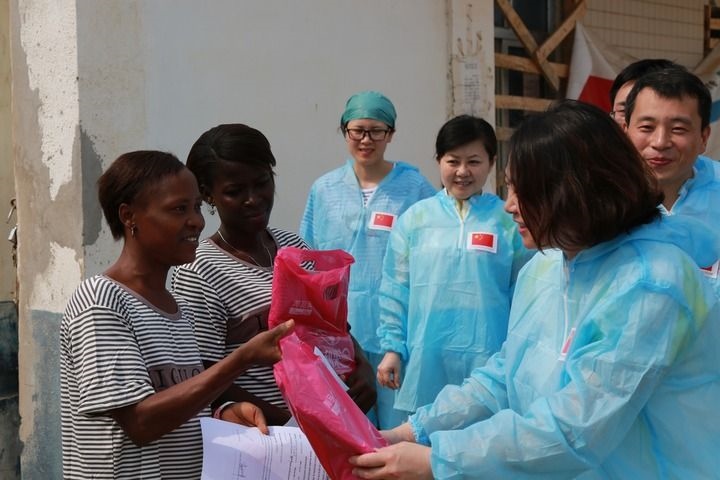 2015年4月4日，在位于塞拉利昂首都弗里敦市郊的中塞友好醫(yī)院埃博拉診療中心，中國(guó)第四批援塞醫(yī)療隊(duì)副隊(duì)長(zhǎng)邵蔚（右前）向被治愈的埃博拉出血熱患者贈(zèng)送禮物。新華社發(fā)（祖榮強(qiáng) 攝）