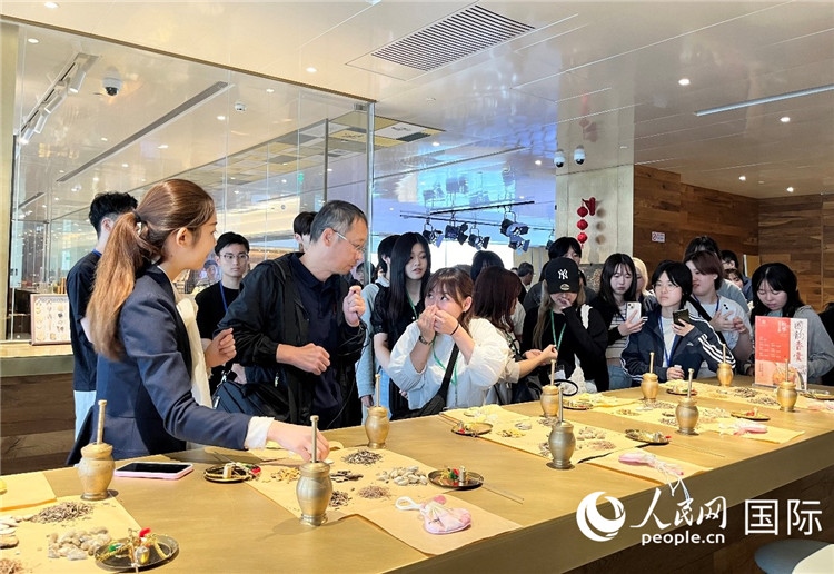1. 日中友好協(xié)會(huì)青年代表團(tuán)一行學(xué)習(xí)中醫(yī)香囊制作工序。（人民網(wǎng)記者陳思 攝）