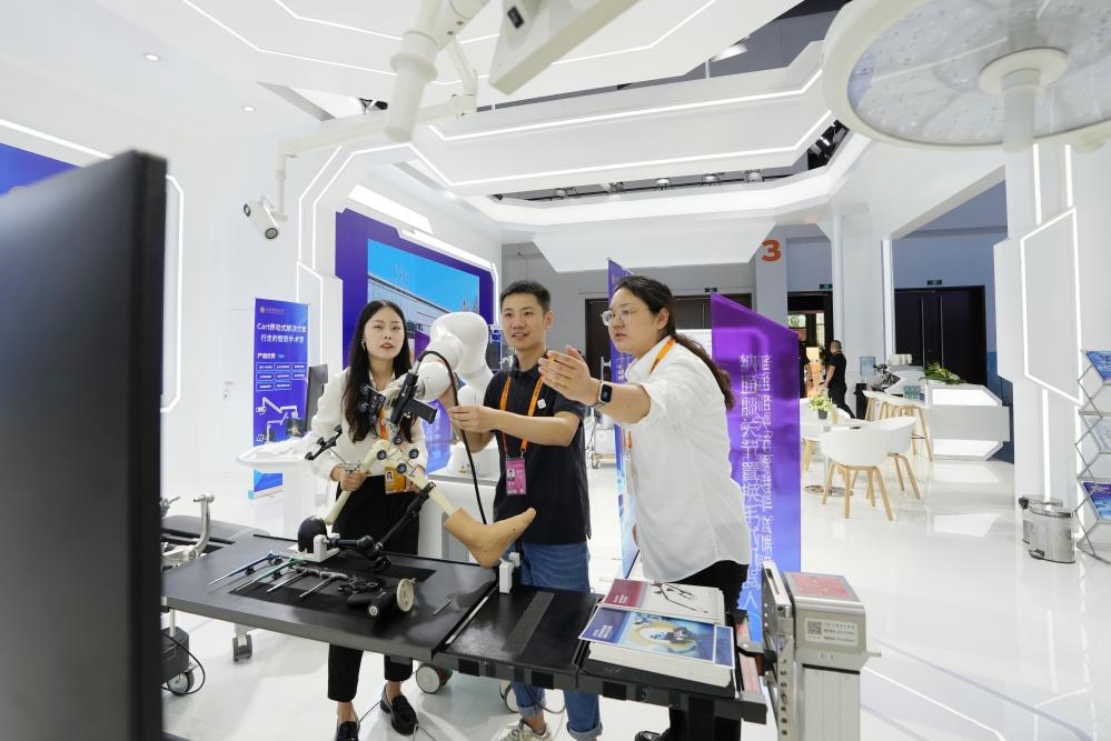 9月11日，一位媒體記者（中）在2024年服貿(mào)會(huì)國(guó)家會(huì)議中心會(huì)場(chǎng)體驗(yàn)北京納通科技集團(tuán)有限公司的膝關(guān)節(jié)置換手術(shù)機(jī)器人。新華社記者鞠煥宗 攝
