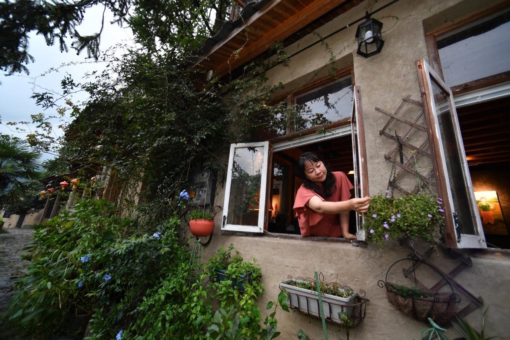 8月29日，在福建省屏南縣熙嶺鄉(xiāng)，龍?zhí)洞濉靶麓迕瘛泵泛暝诖蚶碜约航?jīng)營的民宿外墻裝飾花盆。新華社記者姜克紅 攝