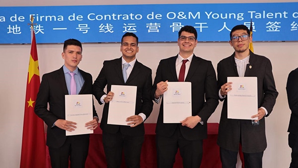 當(dāng)?shù)貢r(shí)間9月13日，40名哥倫比亞青年與中企承建運(yùn)營的波哥大地鐵一號(hào)線項(xiàng)目簽約，不久將前往中國進(jìn)行為期15個(gè)月的專業(yè)地鐵知識(shí)培訓(xùn)。圖為部分學(xué)員在簽約儀式上展示所簽的協(xié)議。 波哥大地鐵一號(hào)線項(xiàng)目供圖