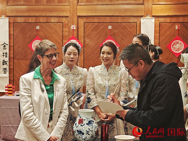 現(xiàn)場的非遺傳承人為英國觀眾展示畫技。人民網(wǎng)記者 邢雪攝