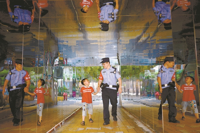 ?7月16日，重慶市公安局江北區(qū)分局一名民警在巡邏途中遇到一個(gè)獨(dú)自玩耍的小男孩，民警將其送回家。王洪平攝