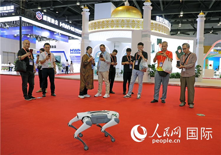 東博會(huì)上，觀眾正在參觀一只機(jī)器狗。綠色能源、新能源汽車、綠色農(nóng)產(chǎn)品等成為本屆東博會(huì)觀眾關(guān)注的焦點(diǎn)。人民網(wǎng)記者 趙益普攝