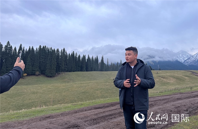 在庫爾德寧，吾買爾江被雪山美景震撼，即興錄制了短視頻作品。人民網(wǎng)記者曾書柔攝