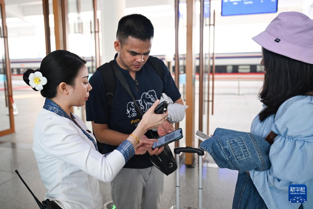 10月12日，在老撾萬(wàn)象中老鐵路萬(wàn)象站，工作人員檢驗(yàn)乘客車票。新華社記者 程一恒 攝